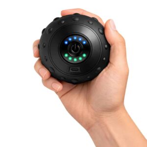 Balle de massage vibrante noire tenue en main pour montrer sa taille compacte