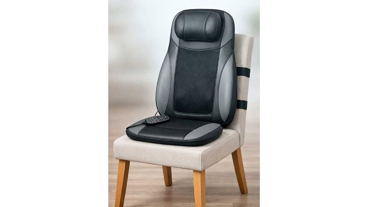 Sur siège massant installé sur une chaise avec télécommande posée sur l’assise
